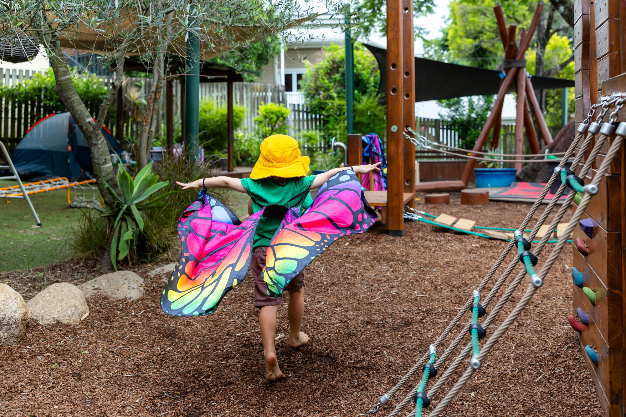 C&K Rosalie - child running through the playground wearing butterfly wings