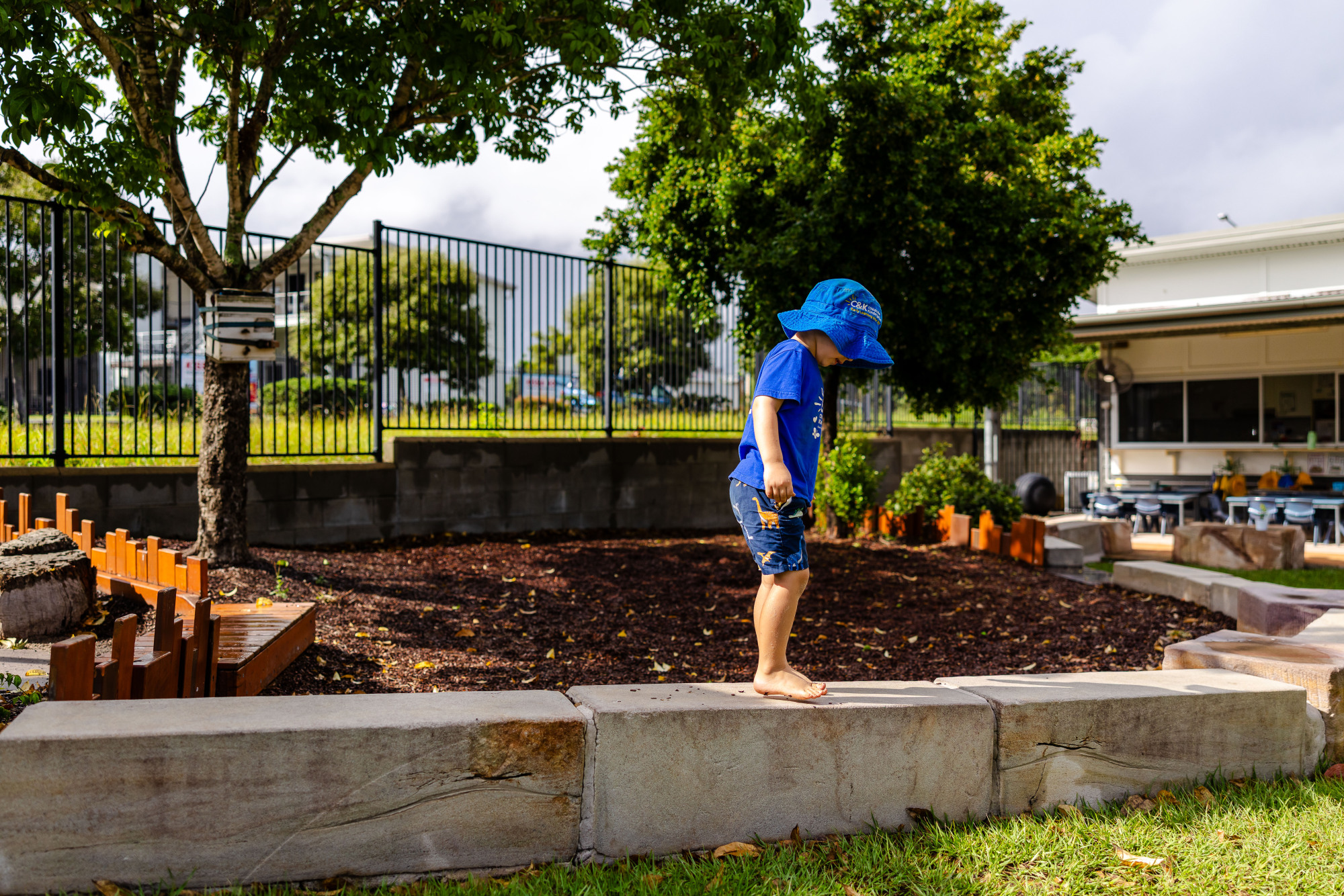 C&K Springfield Central - child balancing on a low stone wall outdoors