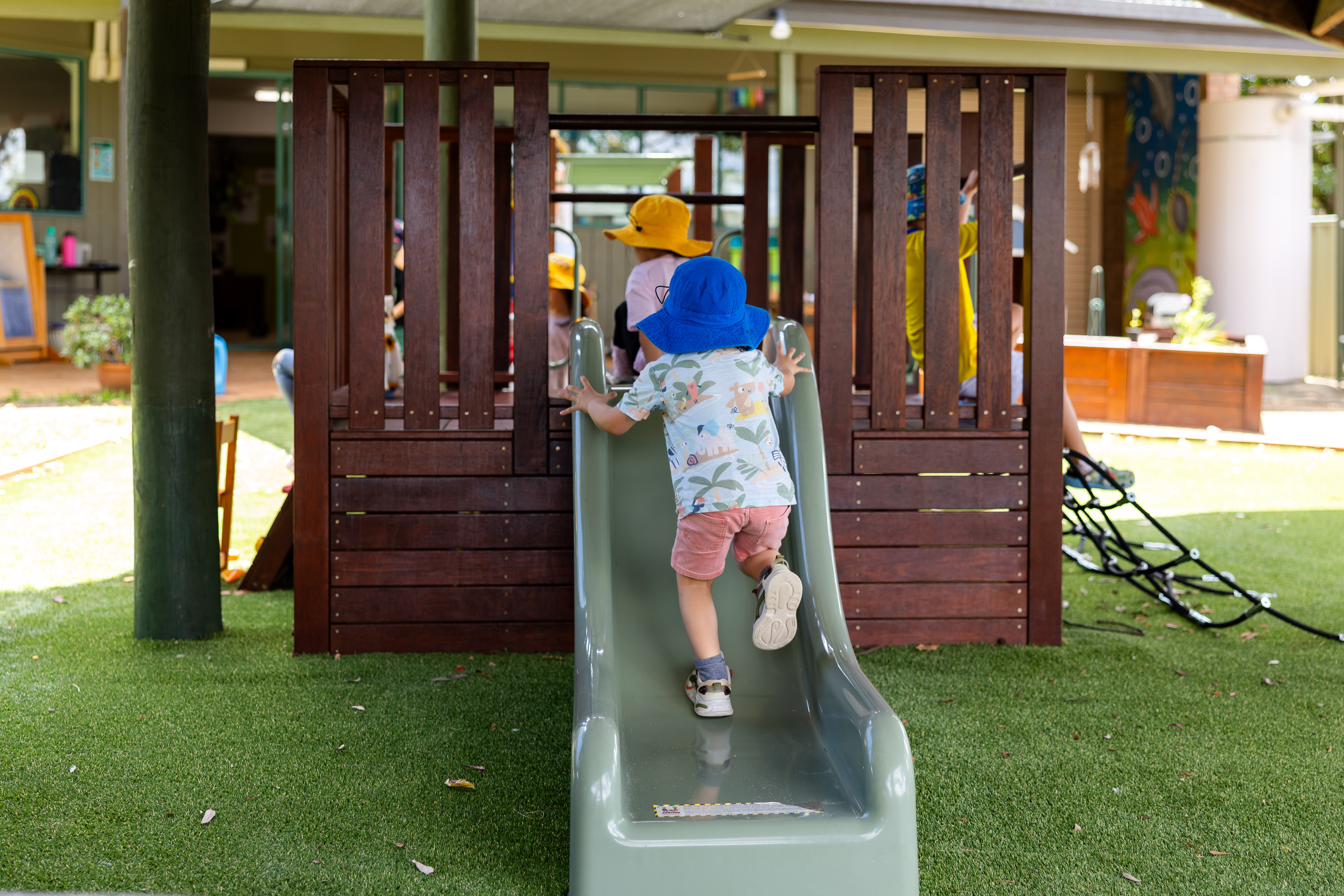 C&K St Catherine's - child climbing up the slide on the playground fort