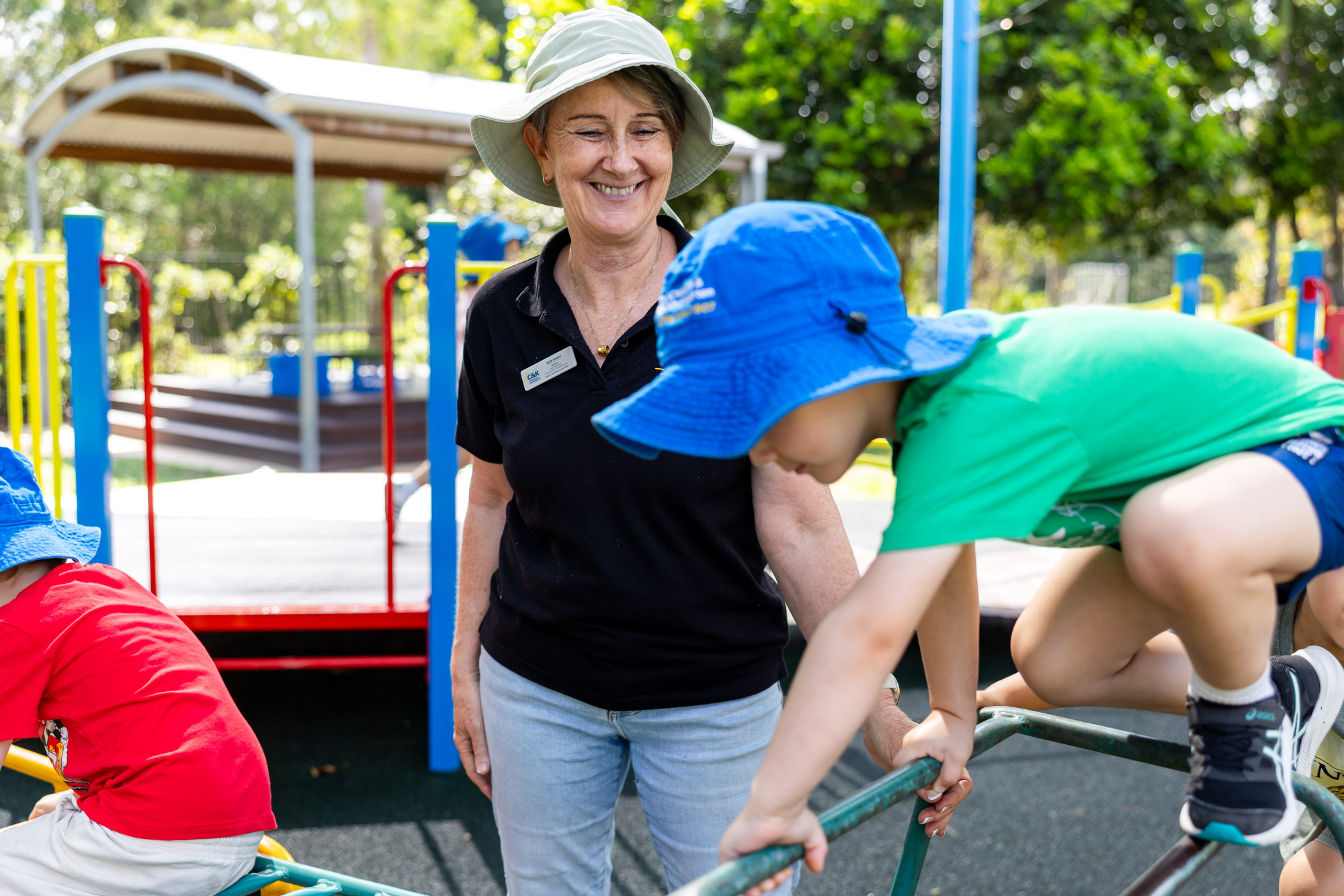 C&K Stretton - educator supervising a child on the climbing frame