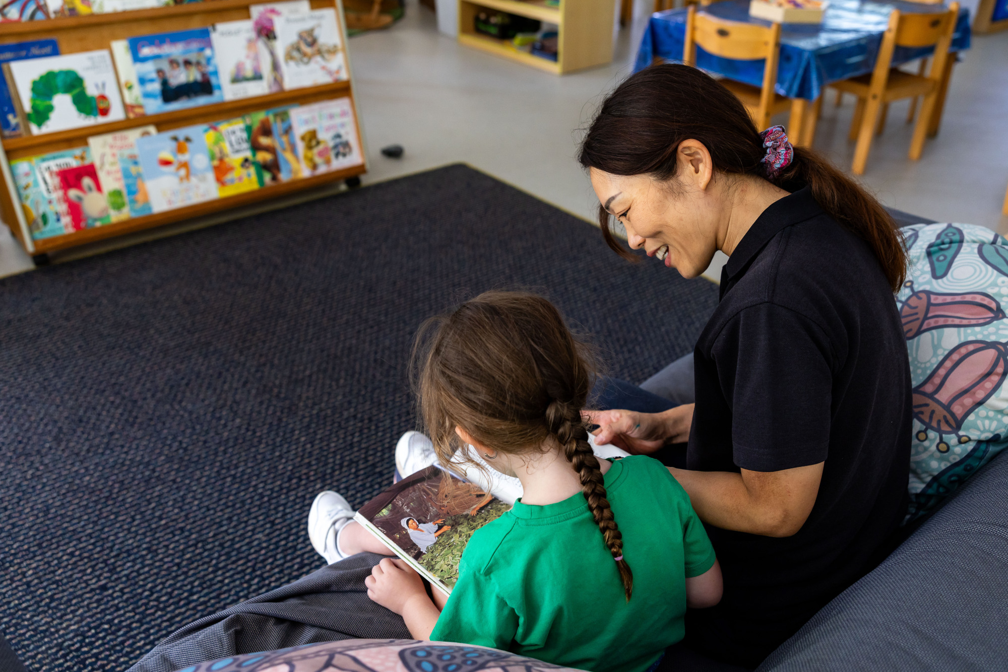 C&K Stretton - educator and child reading on a couch