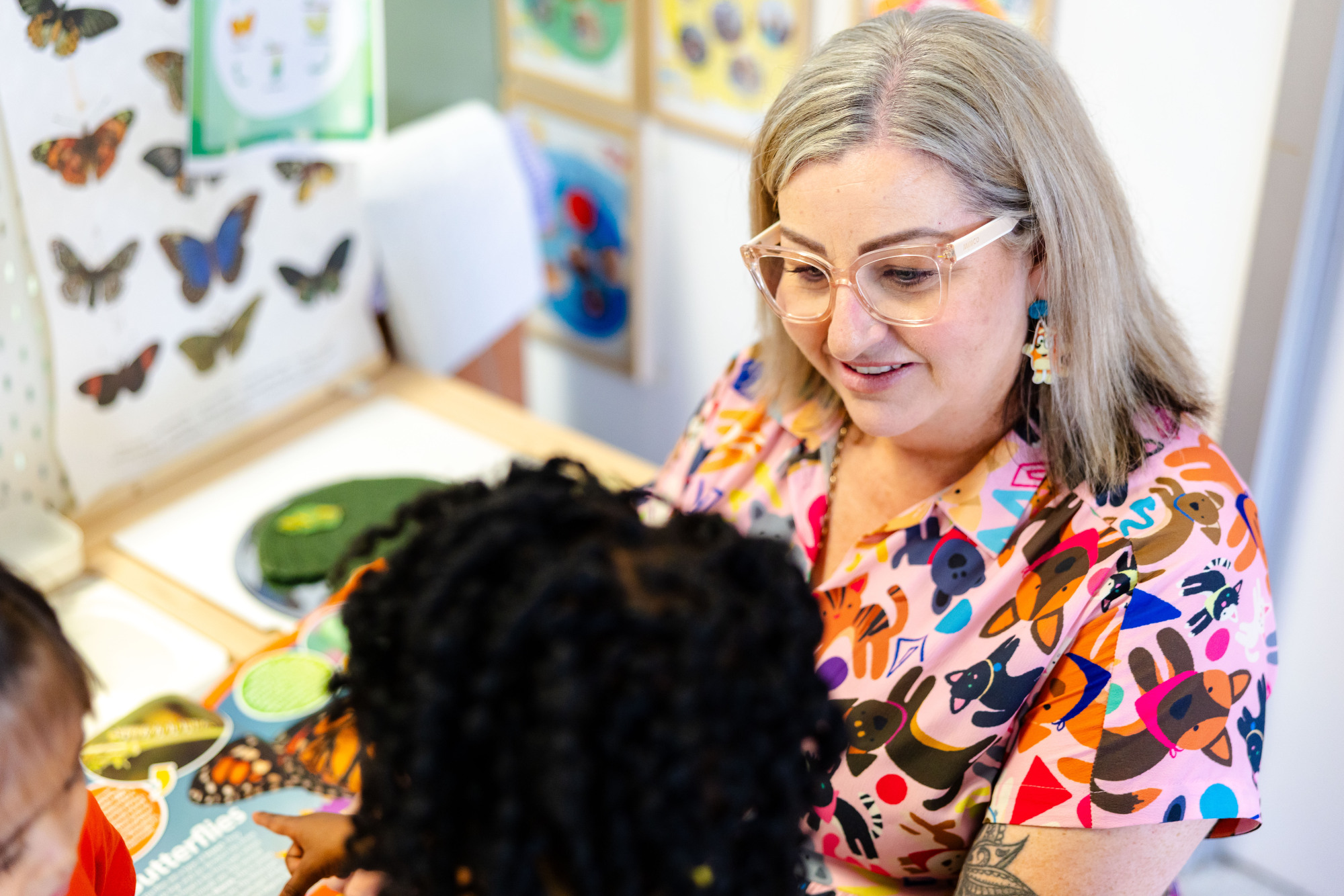 C&K Woodcrest - teacher and children looking at a scientific butterfly display in the classroom