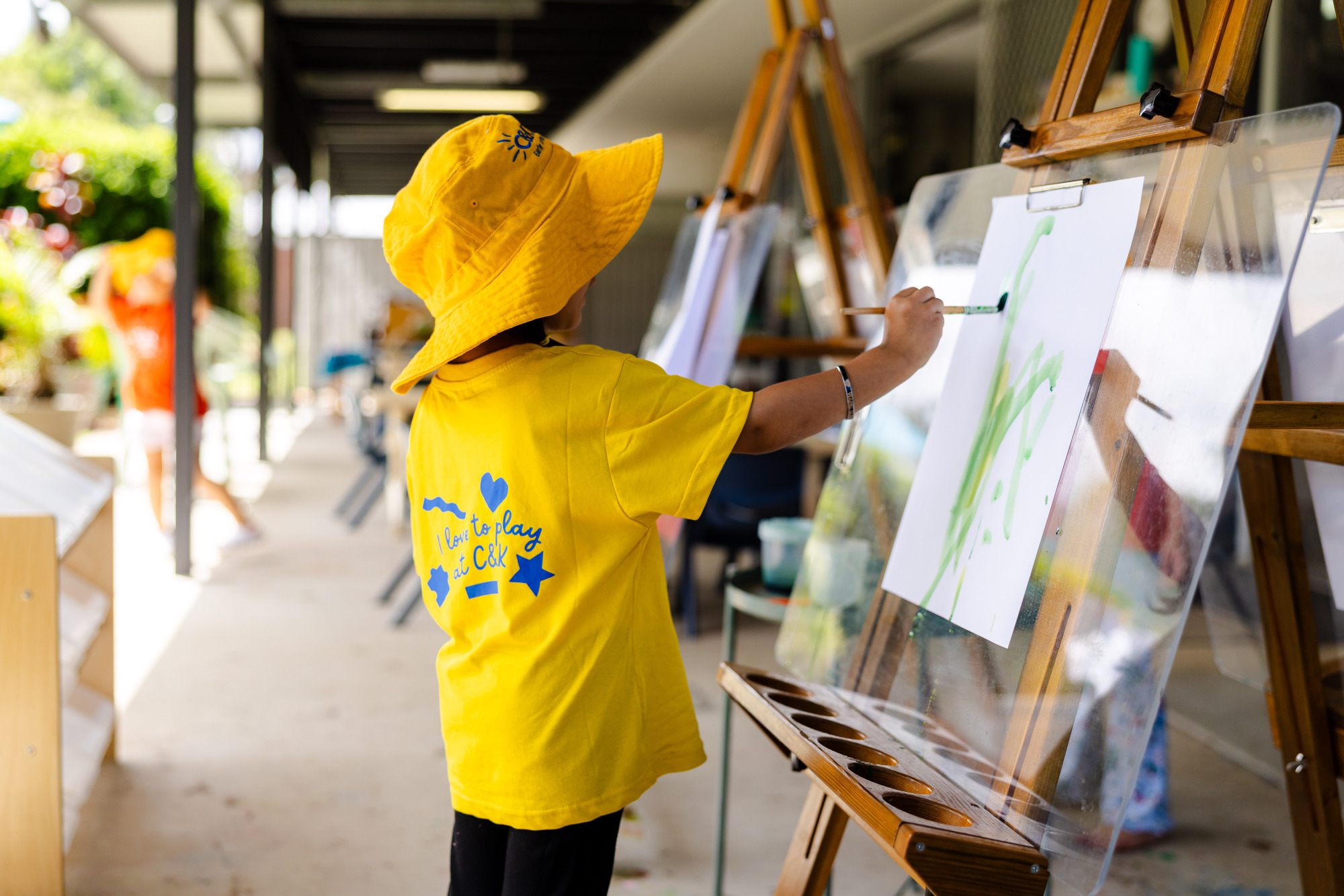 C&K Woodcrest - child painting on the outdoor veranda