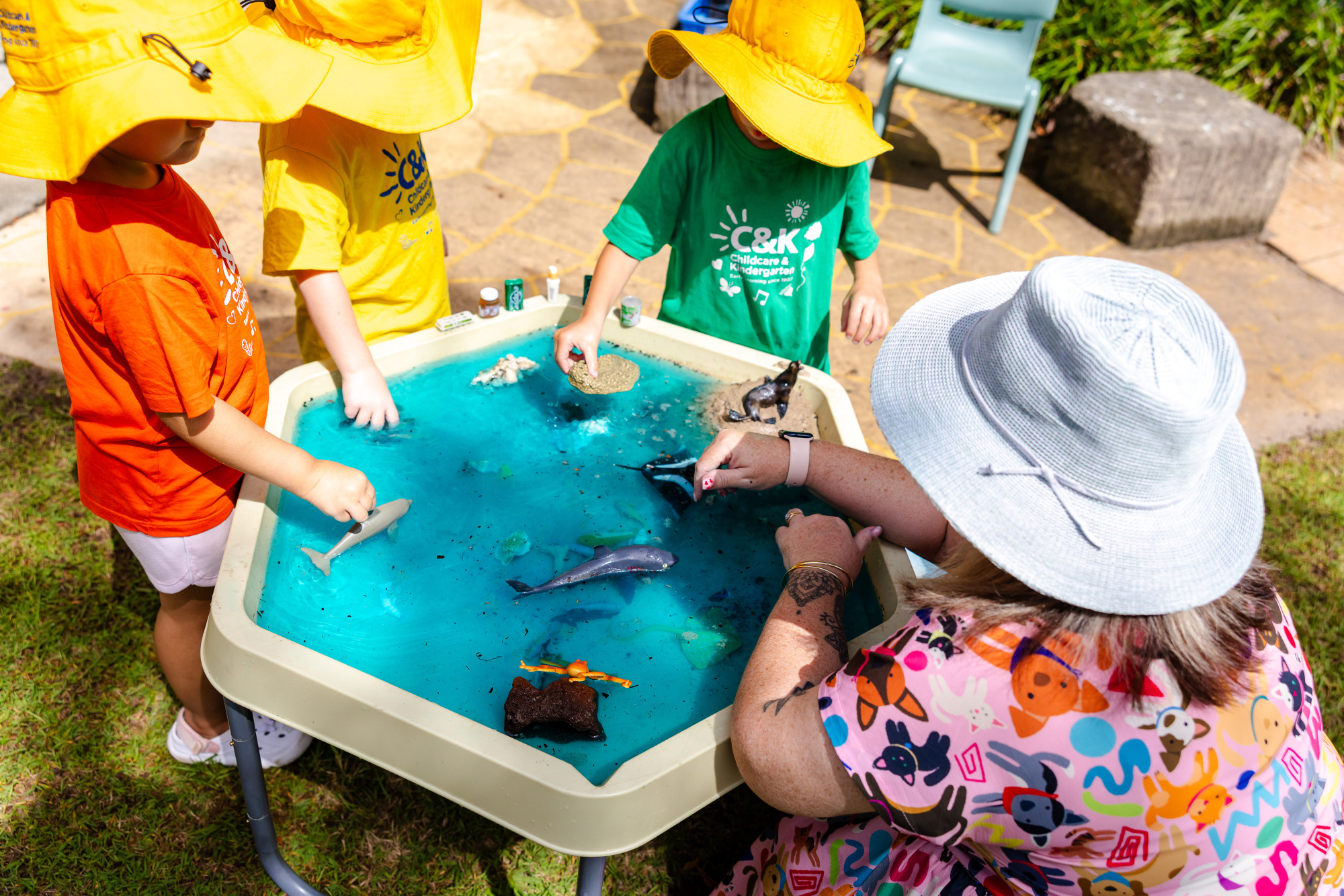 C&K Woodcrest - educator and children playing at a water table