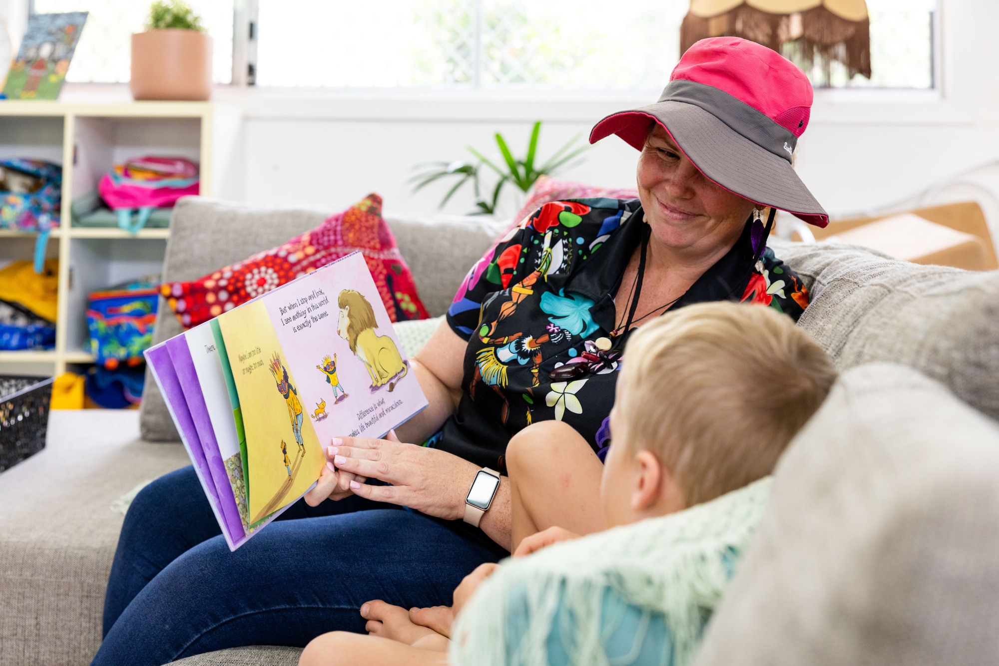 C&K Woodford - educator and child reading indoors on a couch
