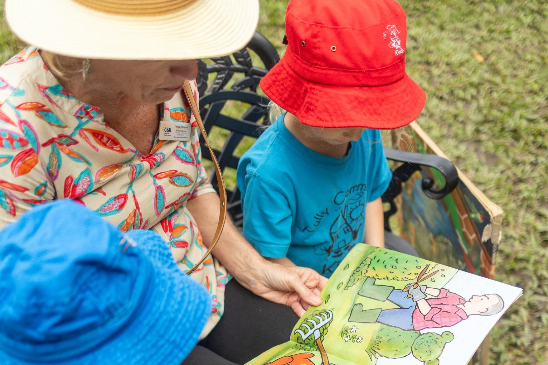 C&K Tully - educator reading to children outdoors
