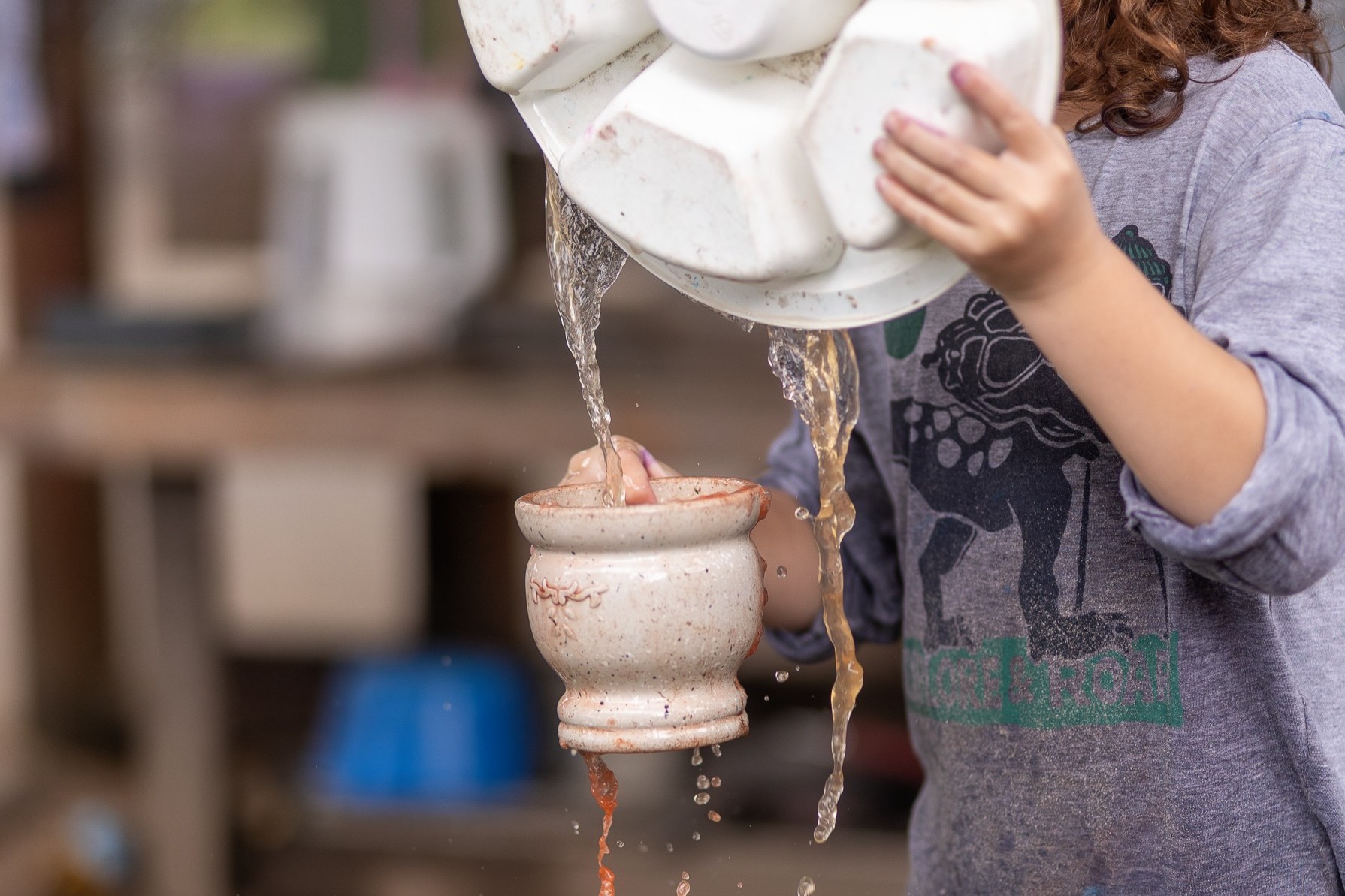 C&K Tully - child playing with water in the mud kitchen