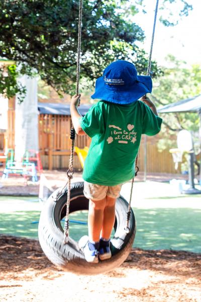 Child standing on a tyre swing in motion