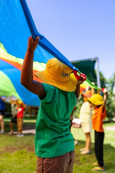 Kindy children playing with rainbow parachute