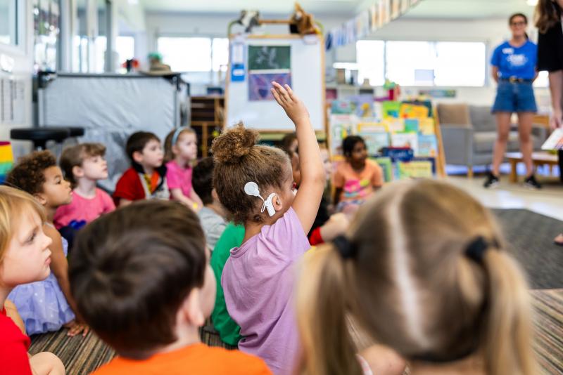 Kindy child putting hand up at group time