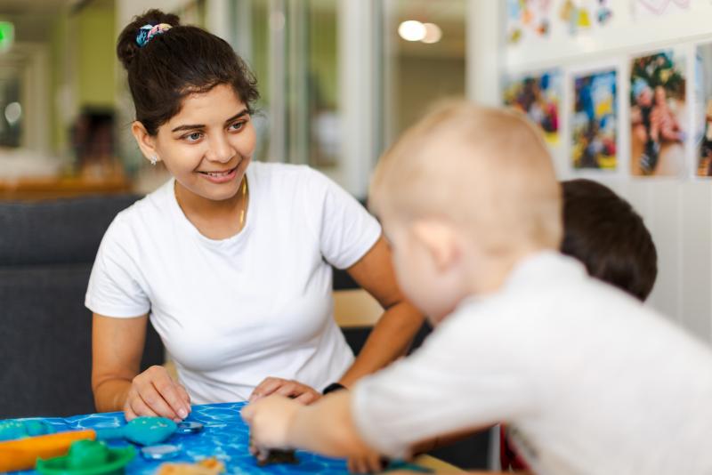 Educator smiling at young baby