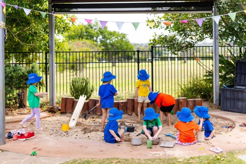 Kindy children outside playing in the sandpit