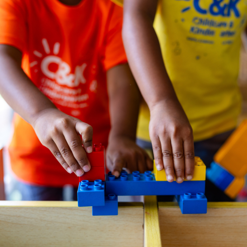 Home page slider 1 - image of children's hands collaboratively playing with Duplo.