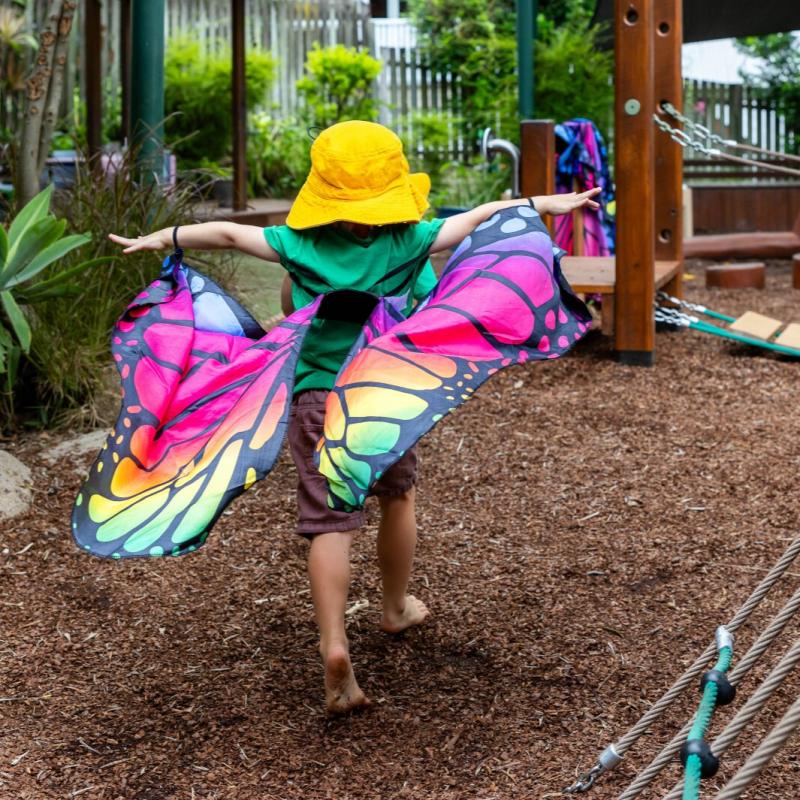 Home page slider 1 - child wearing butterfly wings running through the playground