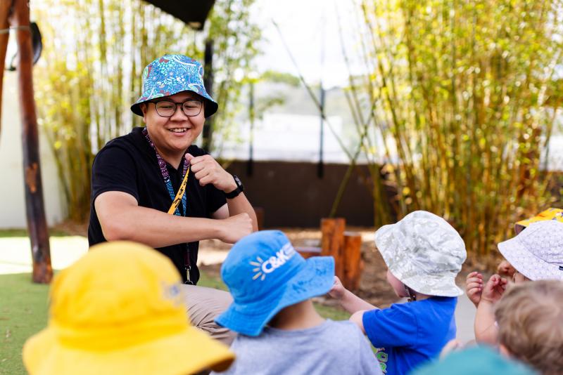 Educator singing outside with children at group time